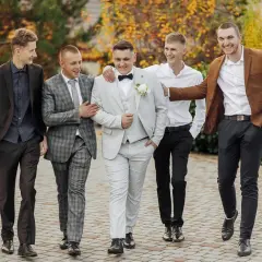 Pięciu panów w eleganckich garniturach, świetny przykład, jak się ubrać na wesele.