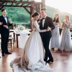 Para pierwszy taniec wybrali stare polskie piosenki. Panna młoda w pięknej sukni i pan młody w garniturze tańczą na weselu.