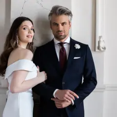 Elegancki pan młody w granatowym garniturze i panna młoda w białej sukni. Idealny wybór, jaki garnitur dla pana młodego.