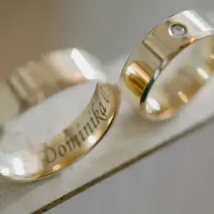 Złote obrączki z wygrawerowanym imieniem "Dominika" i brylantem.