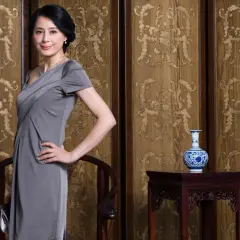 Elegancka mama pana młodego w szarej sukience, gotowa na ślub.