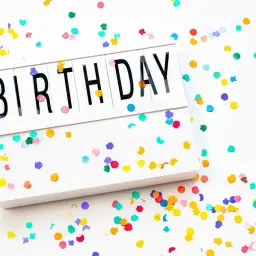 Kolorowe konfetti otacza białą ramkę z napisem "BIRTHDAY". Idealne tło do stworzenia zaproszenia po angielsku na przyjęcie.