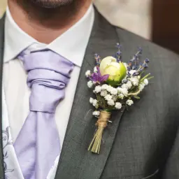 Elegancka butonierka co to? To ozdoba z kwiatów i ziół, przypięta do marynarki. Idealna na ślub i inne uroczystości.