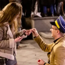Mężczyzna klęczy, oferując pierścionek. To romantyczne oświadczyny, które na pewno zmienią jej życie.