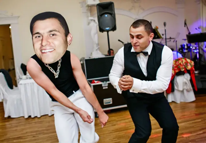 Dwóch mężczyzn tańczy, jeden z gigantyczną głową. To z pewnością śmieszne konkursy zabawy dla dorosłych na imprezie.