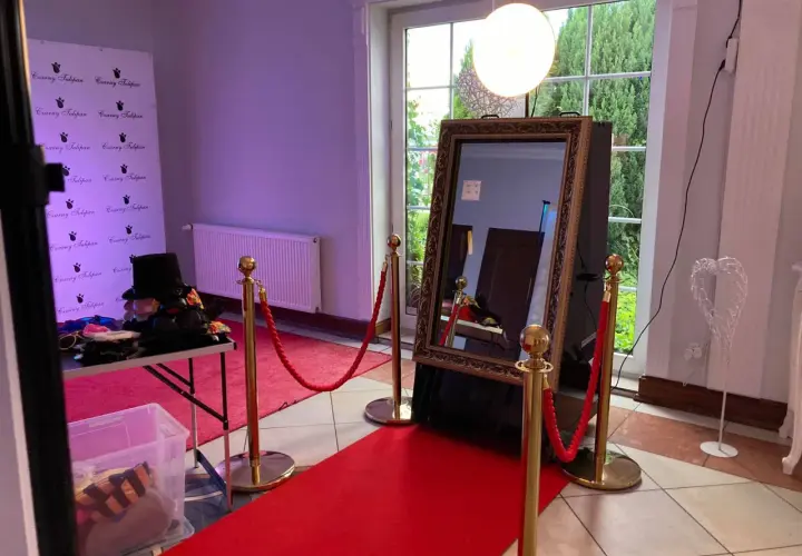 Eleganckie fotolustro na wesele z czerwonym dywanem i rekwizytami do zdjęć. Idealne miejsce na pamiątkowe ujęcia.