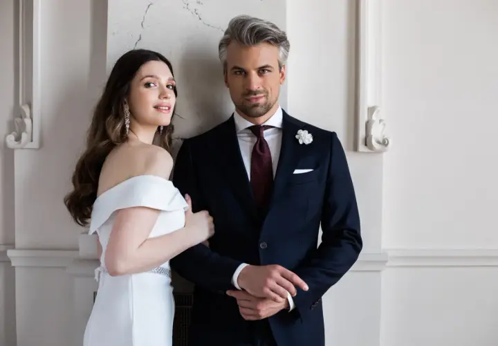 Elegancki pan młody w granatowym garniturze i panna młoda w białej sukni. Idealny wybór, jaki garnitur dla pana młodego.