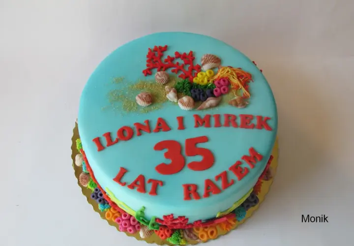 Niebieski tort z motywem morskim na 35 rocznicę ślubu Ilony i Mirka. Dekoracje z koralowców, muszelek i kolorowych cukrowych elementów.
