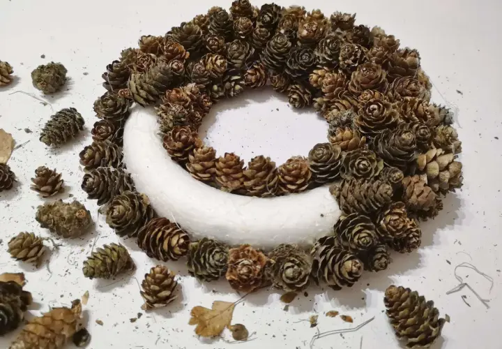 Ozdobny wianek z szyszek, idealny na ślubne dekoracje. Naturalne szyszki tworzą rustykalny urok.