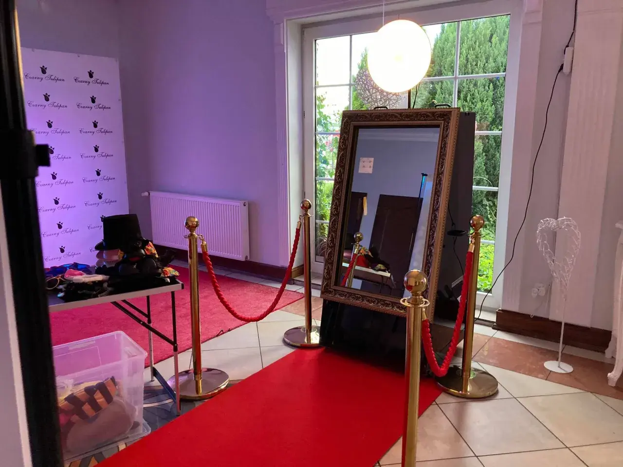 Eleganckie fotolustro na wesele z czerwonym dywanem i rekwizytami do zdjęć. Idealne miejsce na pamiątkowe ujęcia.