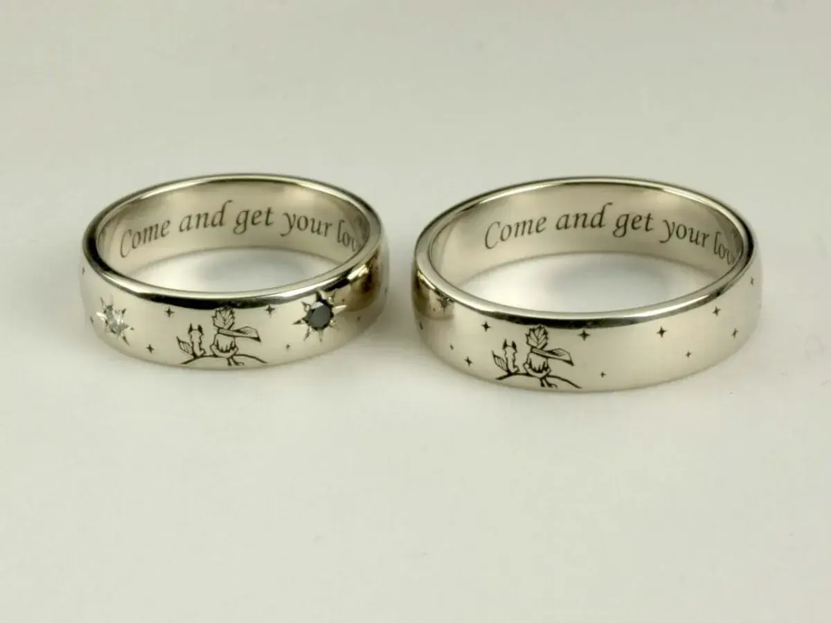 Elegancki grawer na obrączkach z Małym Księciem i lisem. Wewnątrz napis "Come and get your love".
