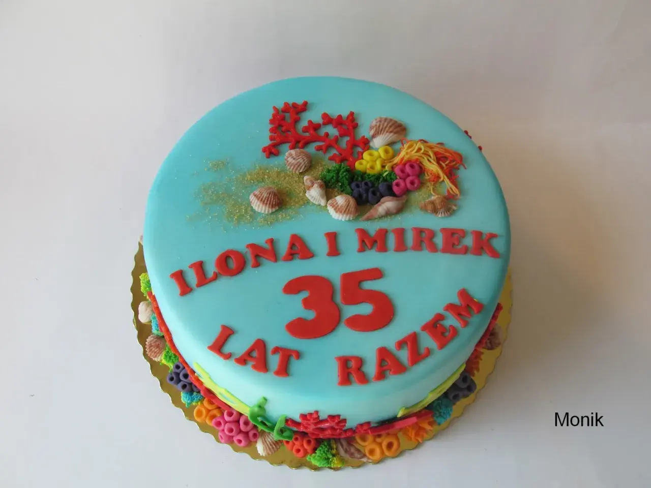 Niebieski tort z motywem morskim na 35 rocznicę ślubu Ilony i Mirka. Dekoracje z koralowców, muszelek i kolorowych cukrowych elementów.
