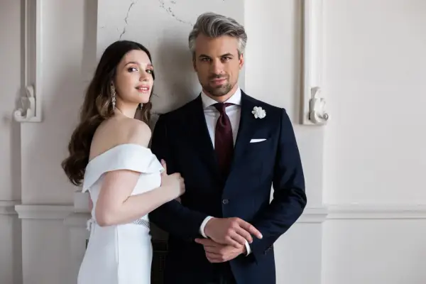 Elegancki pan młody w granatowym garniturze i panna młoda w białej sukni. Idealny wybór, jaki garnitur dla pana młodego.